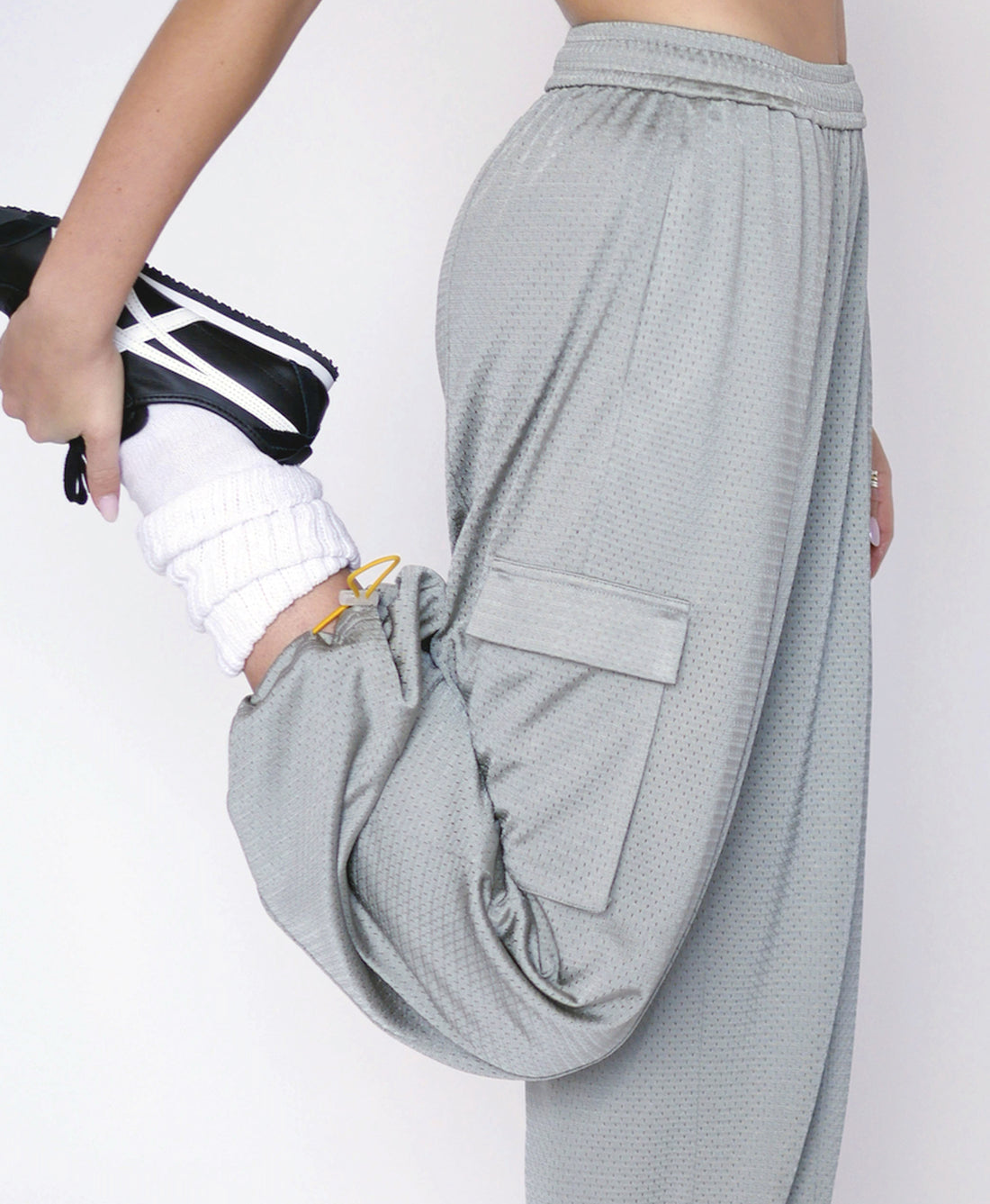 Wear One's At Arena Pant in mineral on model stretching right leg side view
