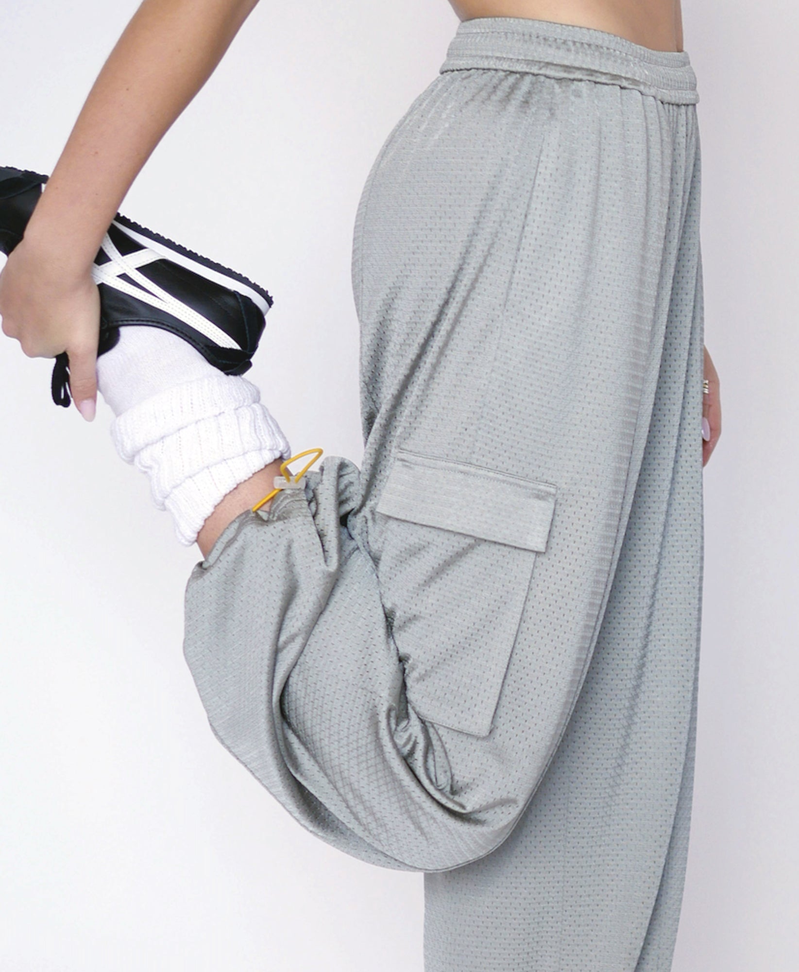 Wear One's At Arena Pant in mineral on model stretching right leg side view