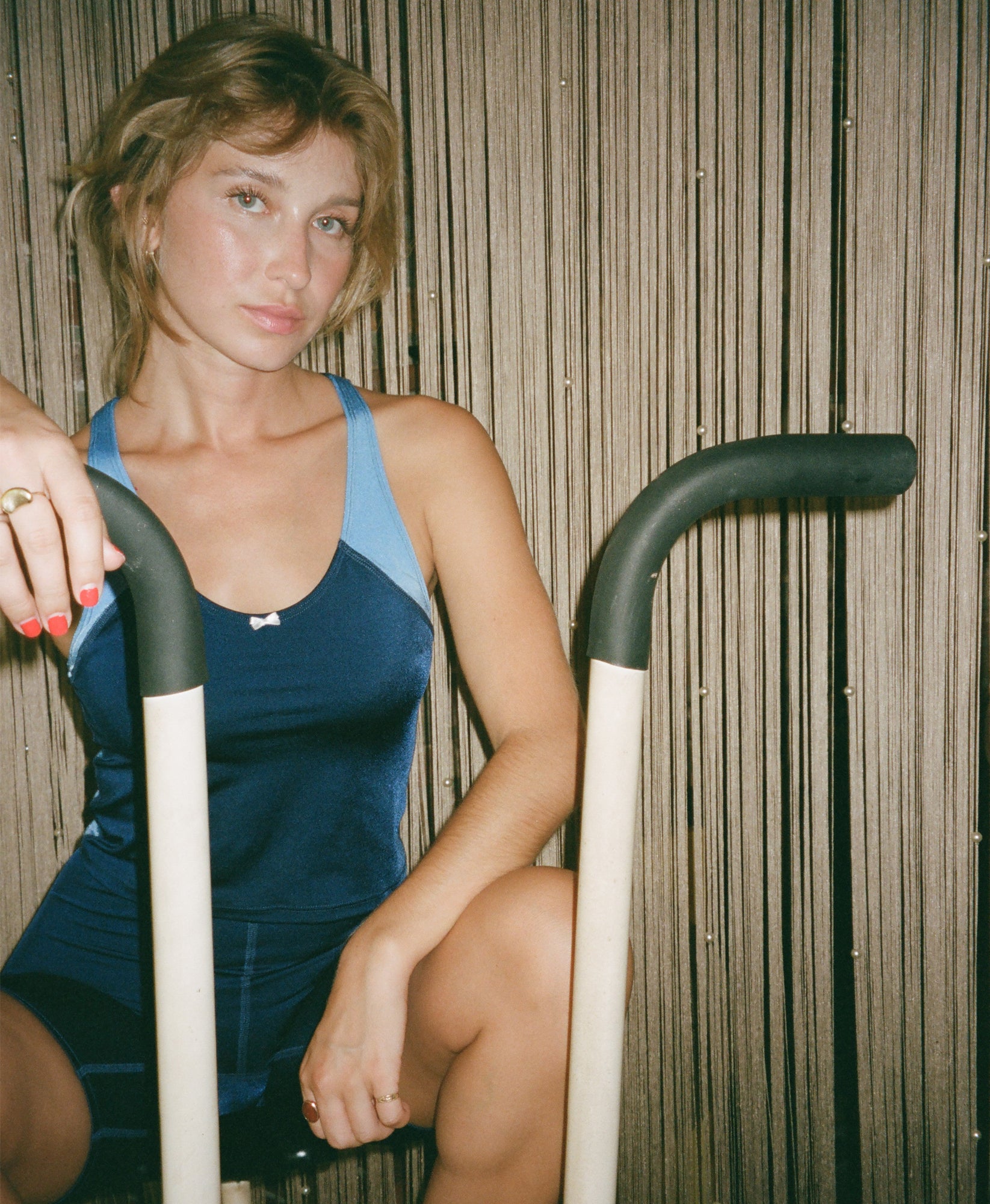 Wear One's At High Jump Tank in navy and sky blue on model sitting on elliptical