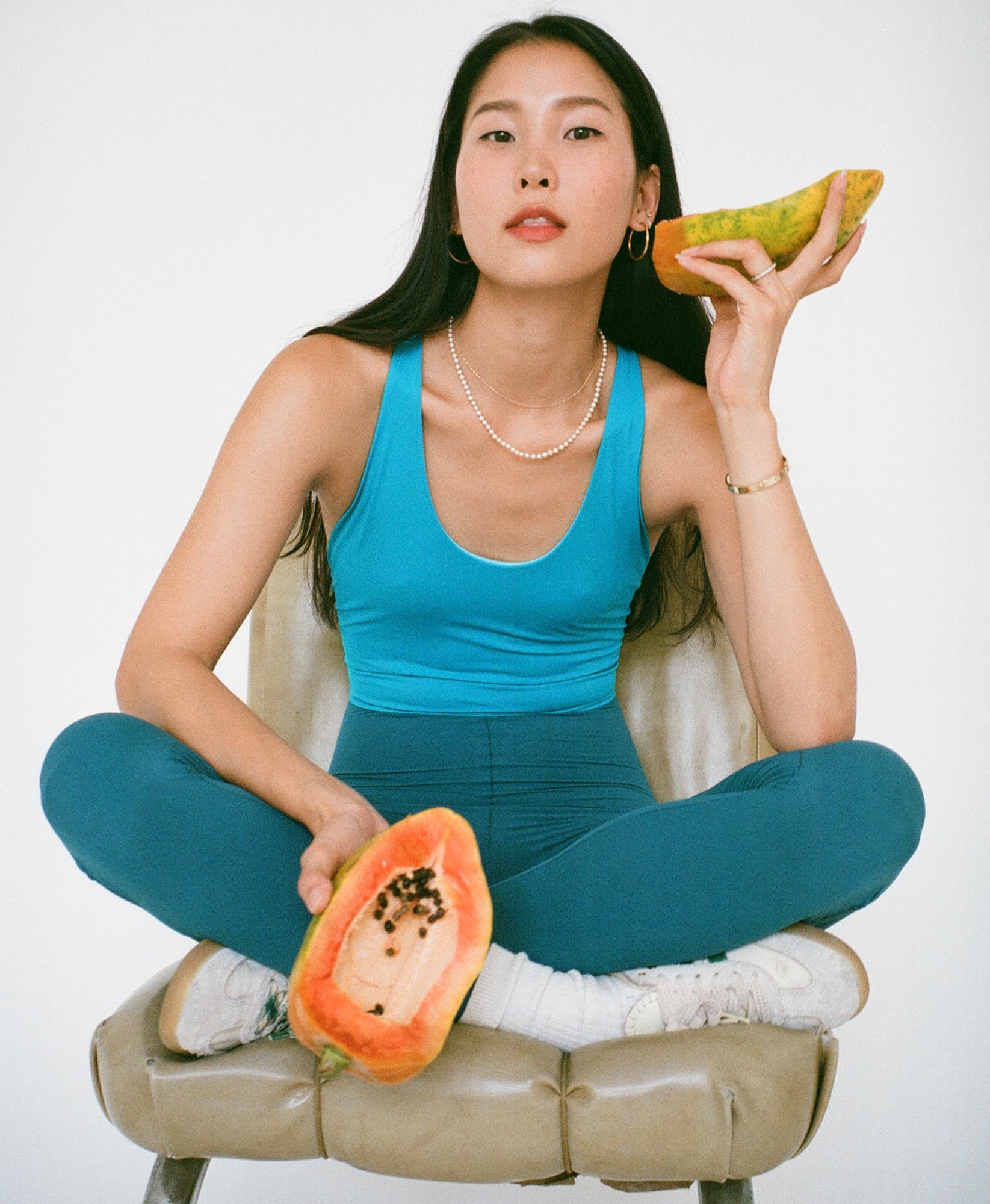 Wear One's At Liberty Unitard in Bondi and teal on model sitting Indian style on a stool