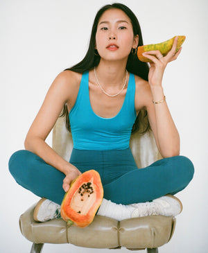 Wear One's At Liberty Unitard in Bondi and teal on model sitting Indian style on a stool