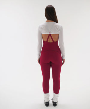 Wear One's at Liberty Unitard in tango red on model wearing a white shrug back view