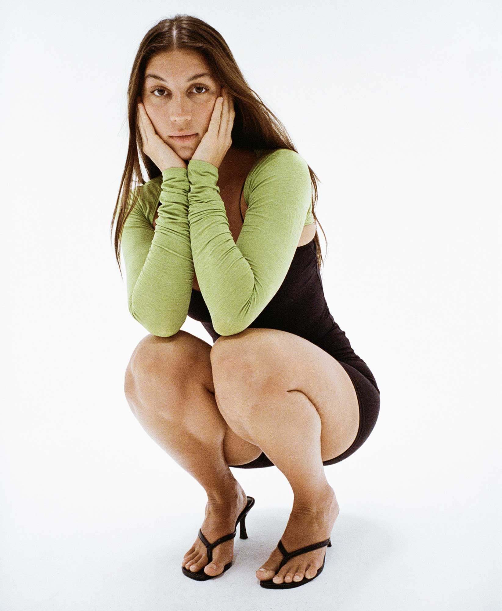 Wear One's At The Scrunch Shrug in Kiwi Green on model bending at knees front view