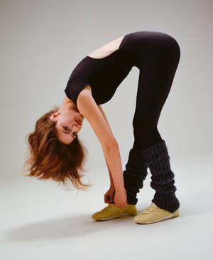 Wear One's At Varsity Unitard in Shadow on model stretching while looking at the camera