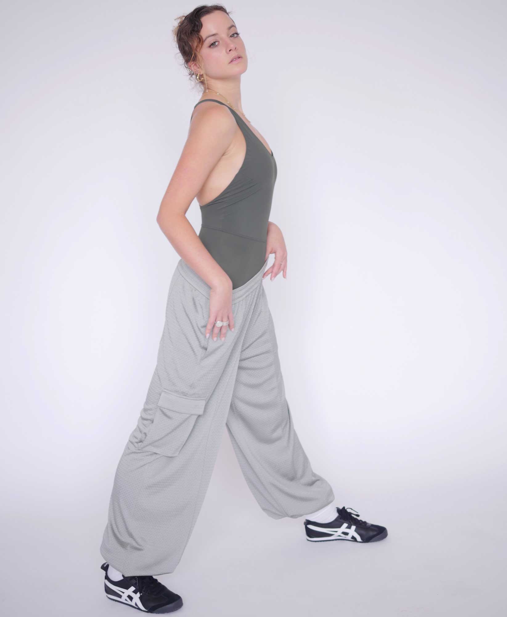 Wear One's At Arena Pant in Mineral Grey on Model Stretching Full Side View