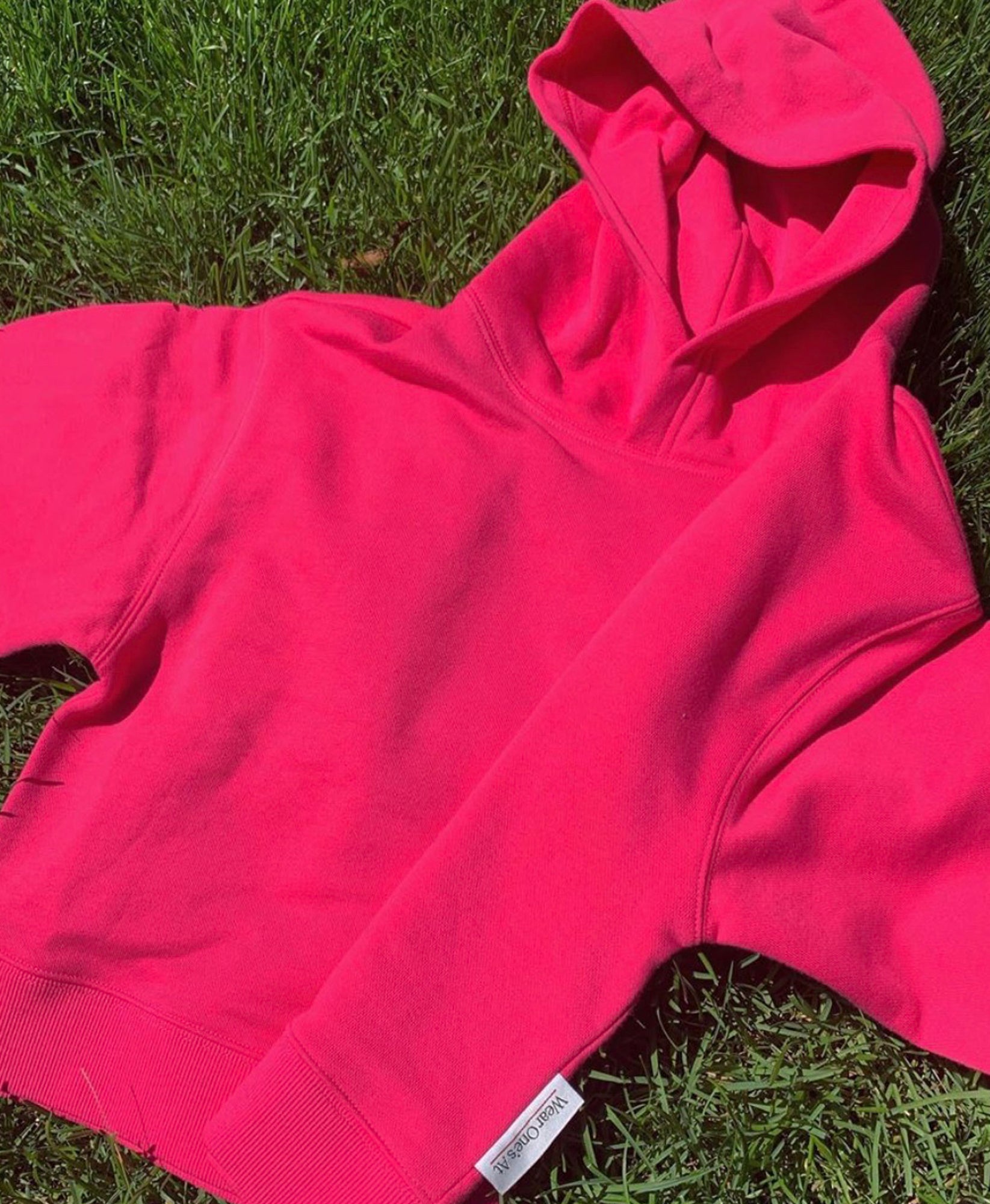 Wear One's At French Terry Cropped Hoodie in Watermelon Laying on Grass Front View